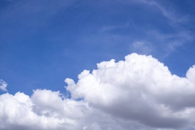 Turkuaz gökyüzünde büyük beyaz bulutlar.