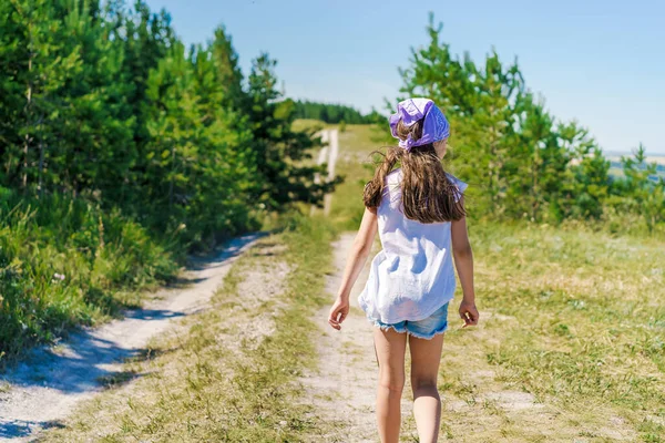 Egy Boldog Kislány Egy Gyerek Kendővel Farmernadrággal Sétál Ösvényen Zöld — Stock Fotó