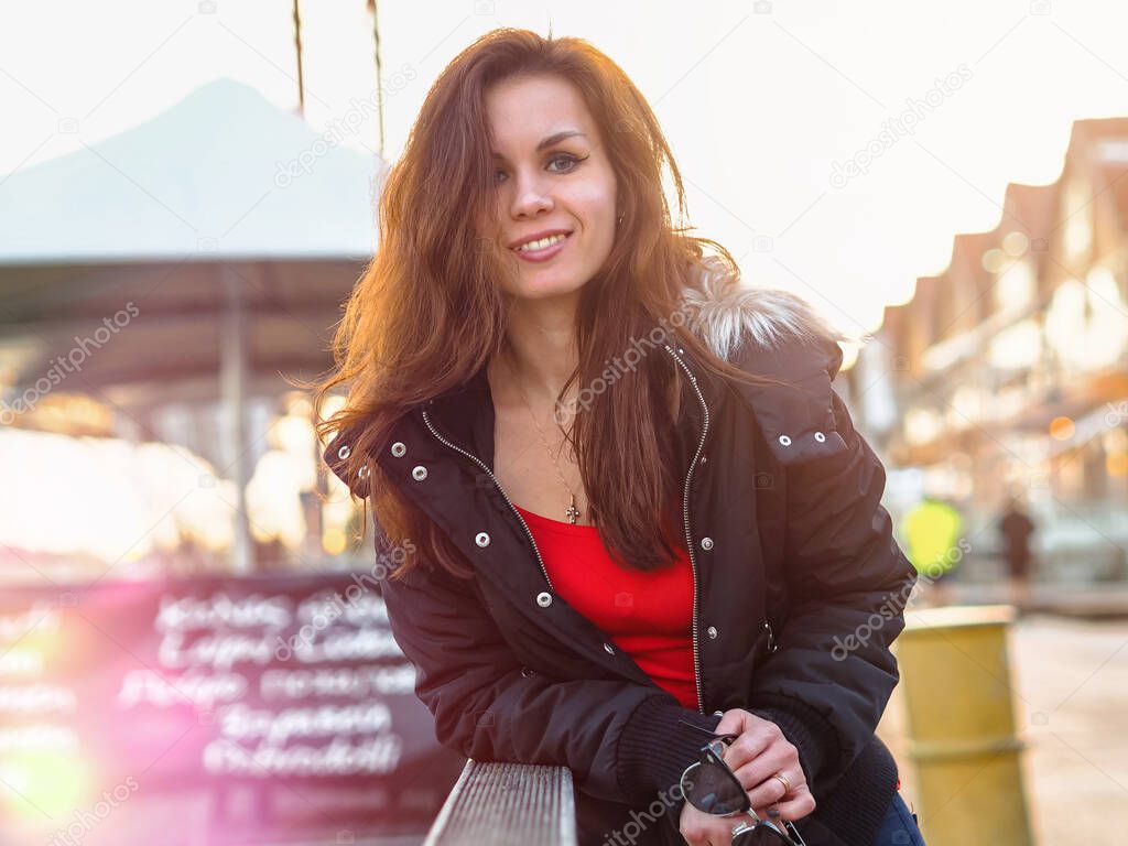 Portrait of a beautiful young woman in a jacket on a European street with bokeh