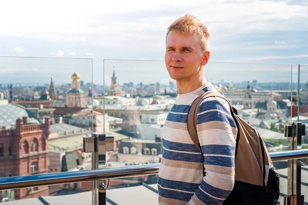 A young man on the roof with a panorama of Moscow, Russia