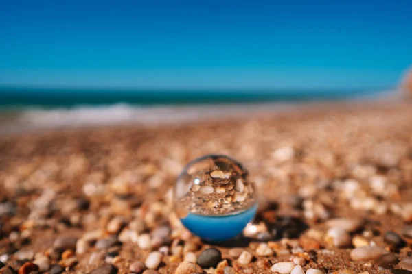 海滩和大海通过水晶球拍照 球的图像对焦了 背景也不对焦了 — 图库照片