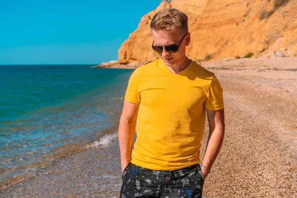 Parlak Elbiseli Güneş Gözlüklü Genç Bir Adam Deniz Kenarında Kumlu — Stok fotoğraf