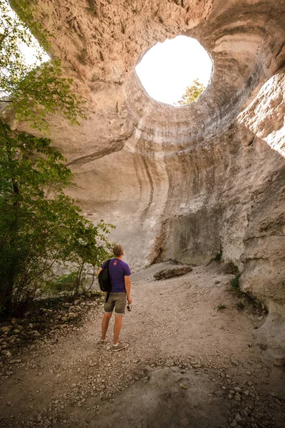 Vista Trasera Joven Aventurero Pie Una Cueva Subterránea Con Agujero —  Fotos de Stock