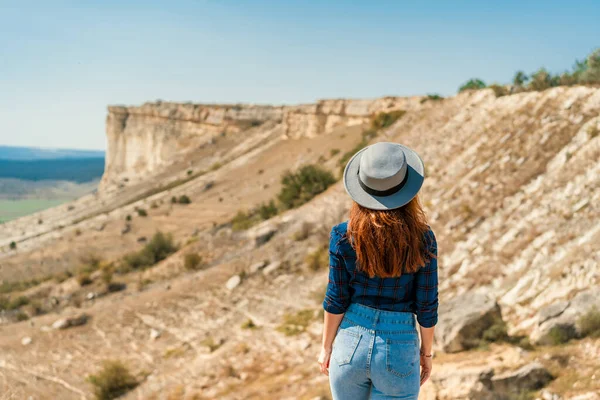 Μια Νεαρή Γυναίκα Καρό Πουκάμισο Και Καπέλο Στέκεται Ένα Βουνό — Φωτογραφία Αρχείου