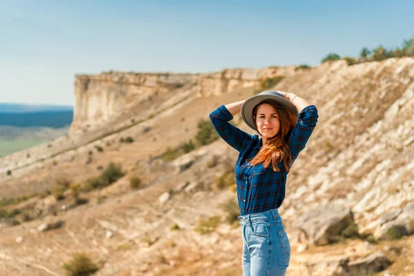 Młoda Kobieta Koszuli Kratę Kapeluszu Stoi Górze Widokiem Rustykalny Krajobraz — Zdjęcie stockowe