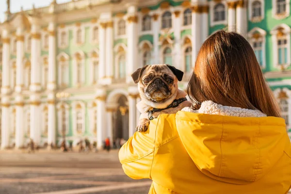 Ung Kvinnlig Ägare Gul Jacka Håller Mops Famnen Ett Turisttorg — Stockfoto