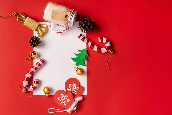 빨간색 배경에는 축제의 크리스마스 장식으로 둘러싸인 백지가 위에서 — 스톡 사진