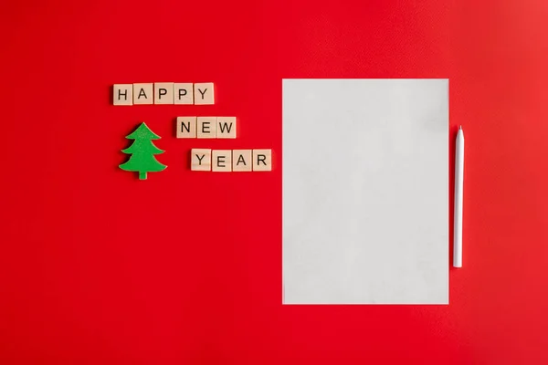 New year\'s concept of a letter to Santa Claus, a white sheet of paper on a red background decorated with Christmas decorations