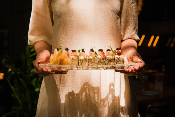 Female holding luxury golden sushi set. Horizontal Stock Photo