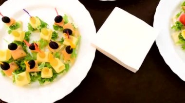 bir parti ya da ziyafet sırasında masada beyaz tabaklarda kanepeler  