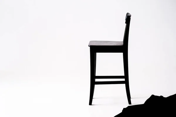 beyaz odada beyaz arka planda siyah sandalye 