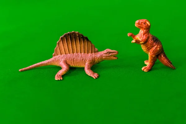 children\'s toys on a green background - dinosaurs