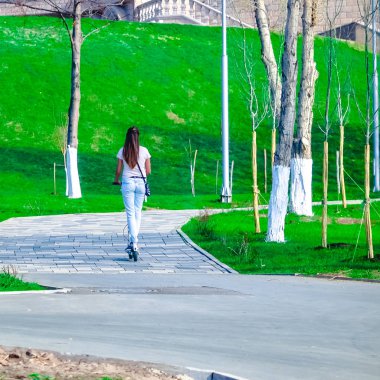 gezinti yolu boyunca yürüyen insanlar, Bisiklet ve scooter, nehir veya deniz akan su izlerken 