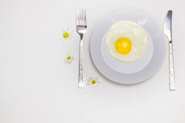 beyaz bir tabak ve eklemeler ile parlak beyaz bir masa üzerinde çırpılmış yumurta 