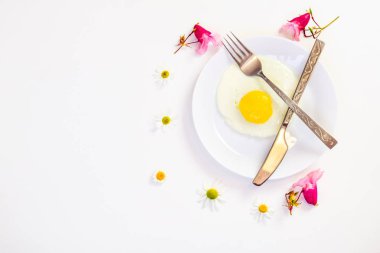 beyaz bir tabak ve eklemeler ile parlak beyaz bir masa üzerinde çırpılmış yumurta 