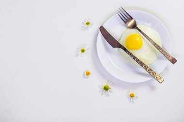 beyaz bir tabak ve eklemeler ile parlak beyaz bir masa üzerinde çırpılmış yumurta 