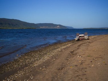 Tekne ya da motorlu tekne ve yazın güneşli bir günde kumlu bir sahilde donanım. 