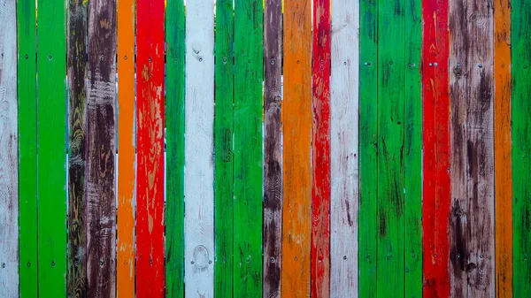fence made of wooden boards painted with different colors of paint