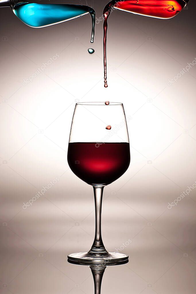 Abstract art of wine glasses, pouring blue and red liquid into wine glass on white background, concept, colorful