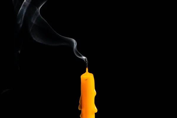 Candle out of fire and white smoke on black background, extinguished