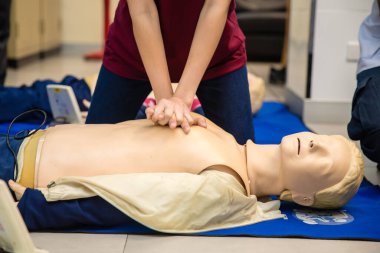 Eller suni teneffüs yapıyor sahte hastaya göğsü pompalıyor, ilk yardım eğitimi alıyor, kalp masajı prosedürünü değiştiriyor.