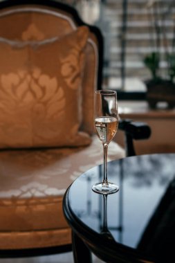 Lokantada bir bar. Masada bir kadeh şampanya var.