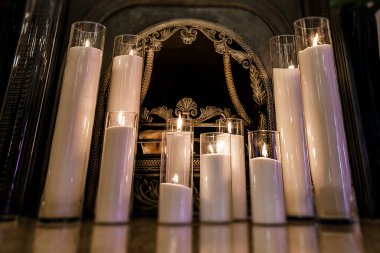 Cam vazolarda mumlarla süslenmiş eski bir şömine..