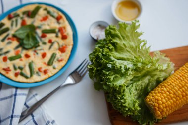 Pizza kapanışı masanın üstünde. Tahtadaki yeşillikler. kompozisyon görünümü yukarıdan