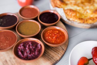 Yuvarlak tabakta baharatlı soslar. Peynir ve sebzeler. Yakın çekim, üst manzara. Gürcistan ulusal mutfağı