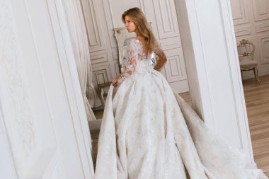 Muhteşem bir gelinlik içindeki gelin, bir fotoğraf stüdyosunda poz veriyor. Eski tasarım