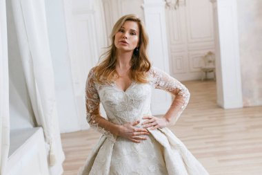 Muhteşem bir gelinlik içindeki gelin, bir fotoğraf stüdyosunda poz veriyor. Eski tasarım