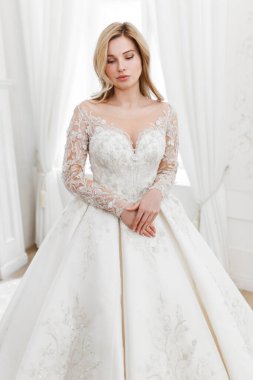 Muhteşem bir gelinlik içindeki gelin, bir fotoğraf stüdyosunda poz veriyor. Eski tasarım