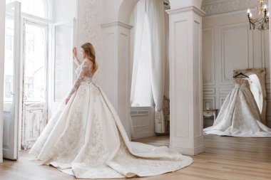 Muhteşem bir gelinlik içindeki gelin, bir fotoğraf stüdyosunda poz veriyor. Eski tasarım