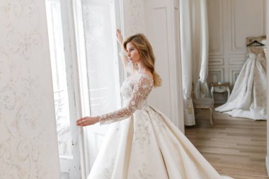 Muhteşem bir gelinlik içindeki gelin, bir fotoğraf stüdyosunda poz veriyor. Eski tasarım