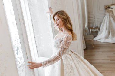 Muhteşem bir gelinlik içindeki gelin, bir fotoğraf stüdyosunda poz veriyor. Eski tasarım