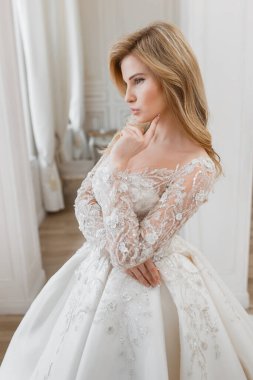 Muhteşem bir gelinlik içindeki gelin, bir fotoğraf stüdyosunda poz veriyor. Eski tasarım