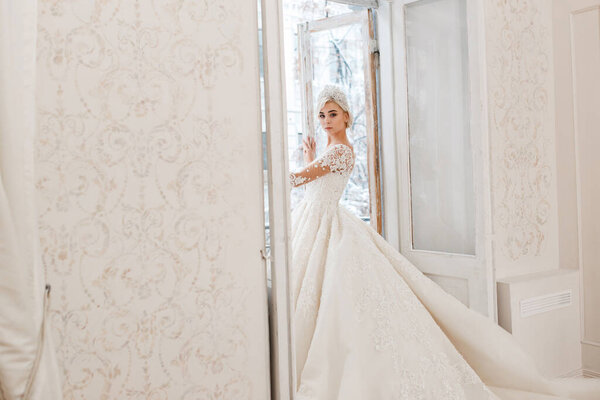 Невеста в белом платье, блондинка позирует в фотостудии. Винтажный интерьер
.