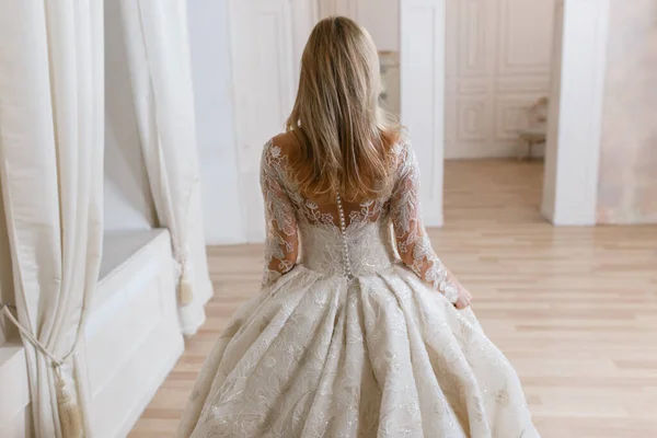 明るいインテリアフォトスタジオにポーズをとる壮大なウェディングドレスで花嫁 ヴィンテージデザイン — ストック写真