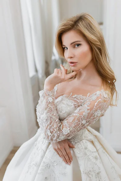 Muhteşem bir gelinlik içindeki gelin, bir fotoğraf stüdyosunda poz veriyor. Eski tasarım