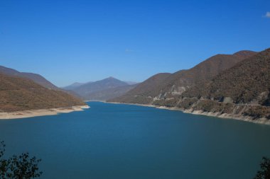 Genç Gürcü çift dağlarda poz veriyor. Georgia 'da Boho düğünü. İyi akşamlar batan güneş. Mavi kot ceket.