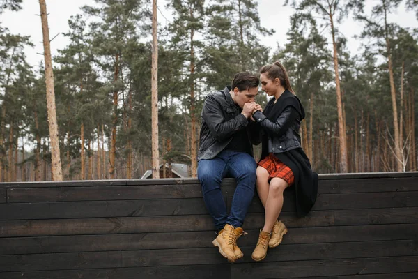 黒いジャケットを着た若いカップルが森の中で抱き合ってポーズをとって — ストック写真