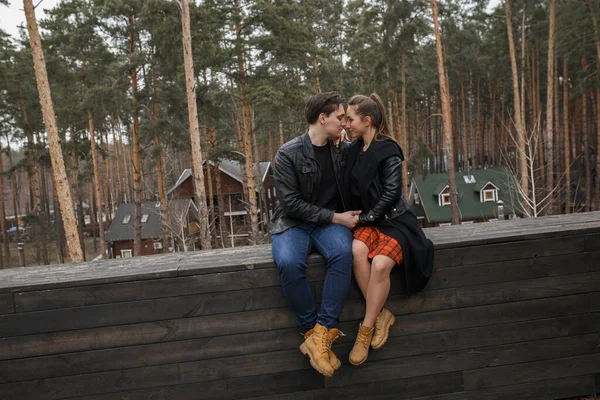 黒いジャケットを着た若いカップルが森の中で抱き合ってポーズをとって — ストック写真