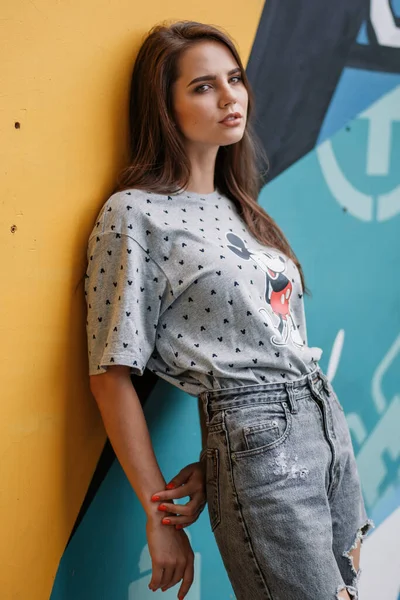 Ragazza Posa Vicino Muro Fiori Blu Gialli Città — Foto Stock