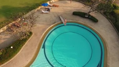 Kız havuzda havuzdan atlıyor.