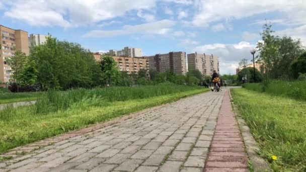 Kinderen rijden op gyroscooter en een fiets op het fietspad — Stockvideo