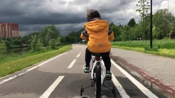Kleine jongen rijdt een kinderfiets op een fietspad — Stockvideo