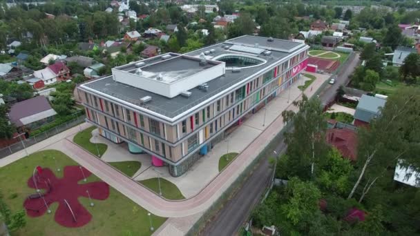 Vide arc-en-ciel belle nouvelle école moderne dans un petit village. aérien wiev — Video