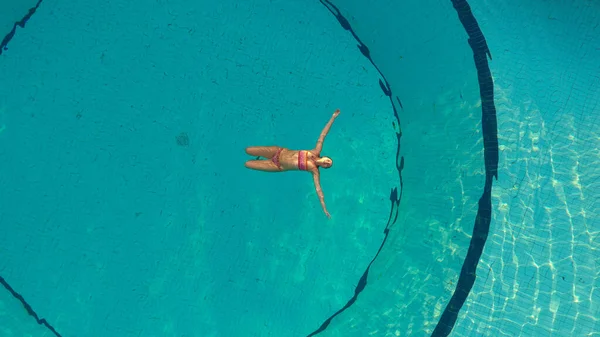 한 젊은 여자 가 수영장에서 수영을 하고 맨 위에서 바라본 모습 — 스톡 사진