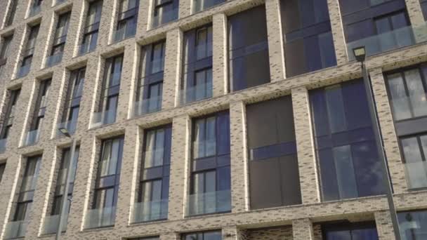 带有彩色玻璃窗户的砖砌高层公寓楼的立面. — 图库视频影像
