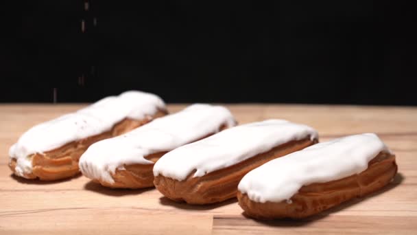 Čtyři z Eclair na řezací desce s bílou náplní, čokoládové lupínky — Stock video